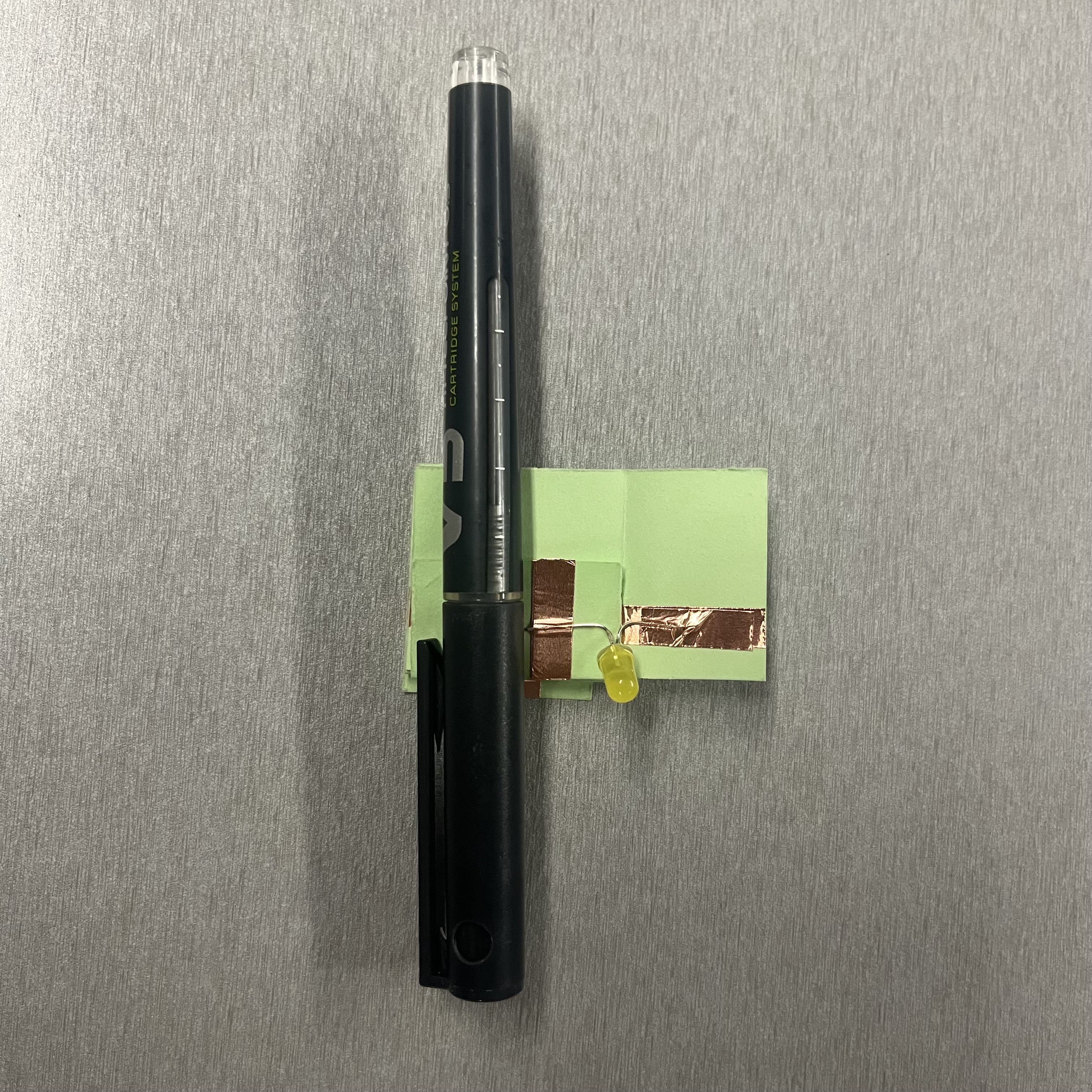 Constructing a paper spring circuit that creates a short circuit when compressed, preventing activation.