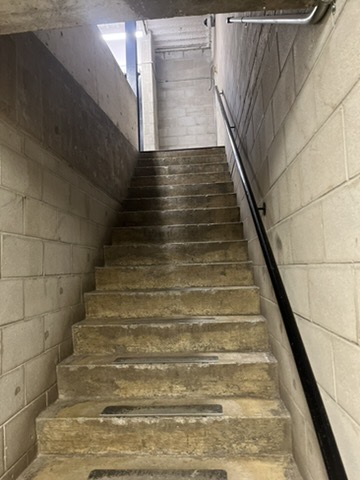 The second location, the concrete stairwell, contrasts sharply with the hallway’s openness. Its rough material, narrow structure, and dim lighting produce an almost fortress-like or dungeon-like feeling, evoking tension and isolation. This transitional vertical space strips away ornamentation to reveal pure function, reflecting the raw honesty of industrial modernism while creating an atmosphere that feels both constrained and introspective. <div class='container'><iframe class='responsive-iframe' src='https://www.youtube.com/embed/tgbNymZ7vqY'></iframe></div>
